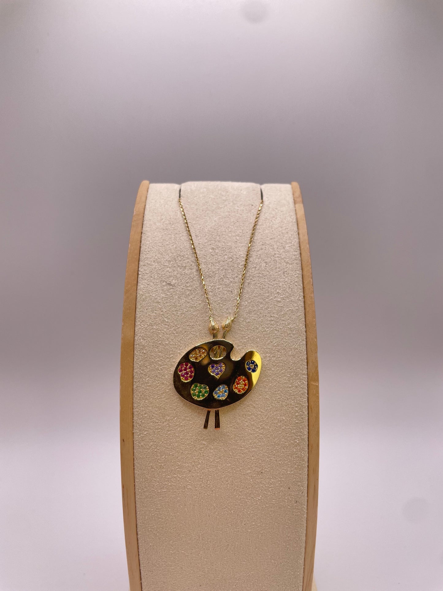 Goldkette mit Farbpalette und bunten Steinen